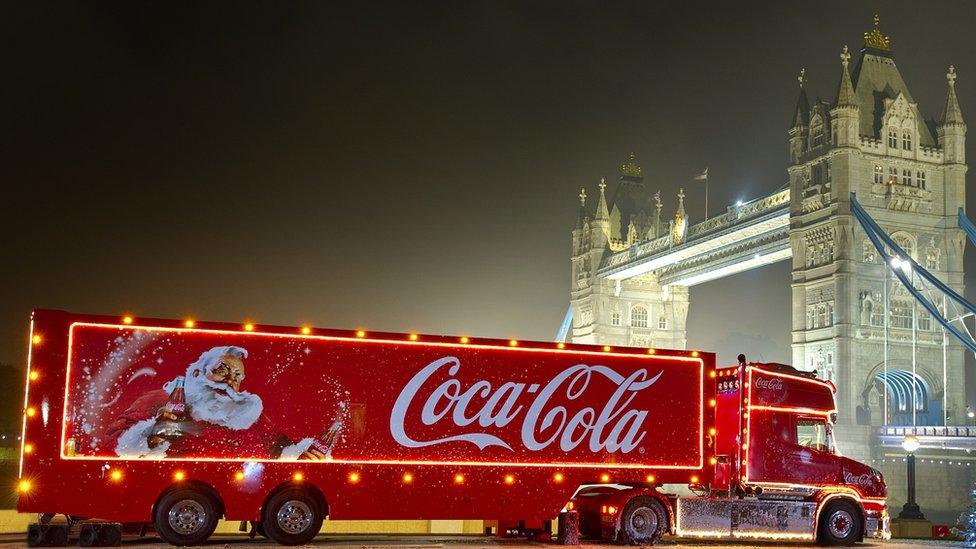 A Coca Cola Christmas truck parking next to the Tower Bridge in London