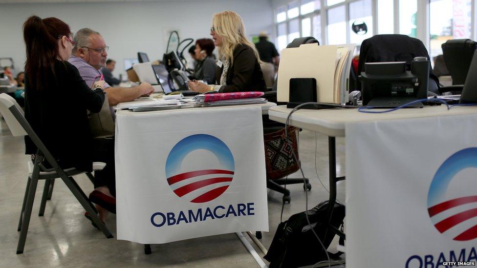 Aymara Marchante (L) and Wiktor Garcia sit with Maria Elena Santa Coloma, an insurance advisor with UniVista Insurance company, as they sign up for the Affordable Care Act, also known as Obamacare, before the February 15th deadline on February 5, 2015 in Miami, Florida