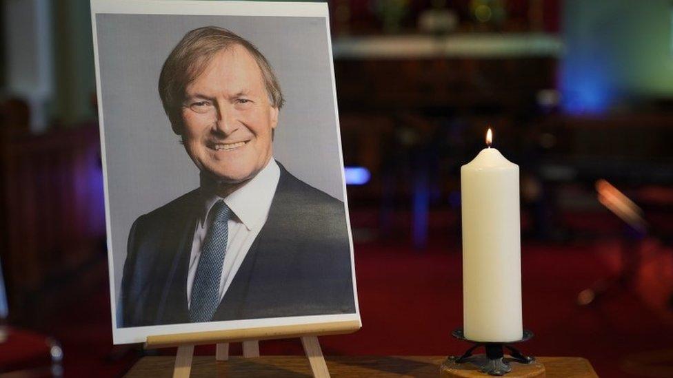 A candle and photo of Sir David Amess at church in Leigh-on-Sea