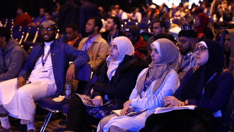 Participants listen to a video message during an MAS-INCA event