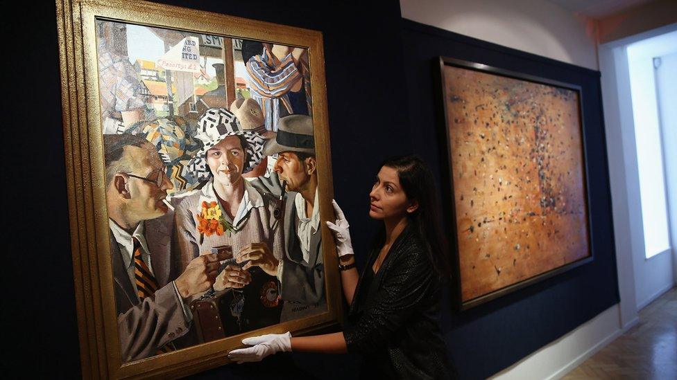 A Bonhams employee poses beside Herbert Badham's 'Travellers' (1933) which was auctioned in 2013