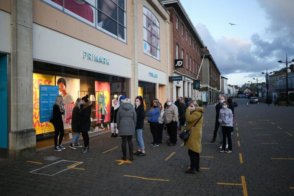 Customers queue outside of a Primark