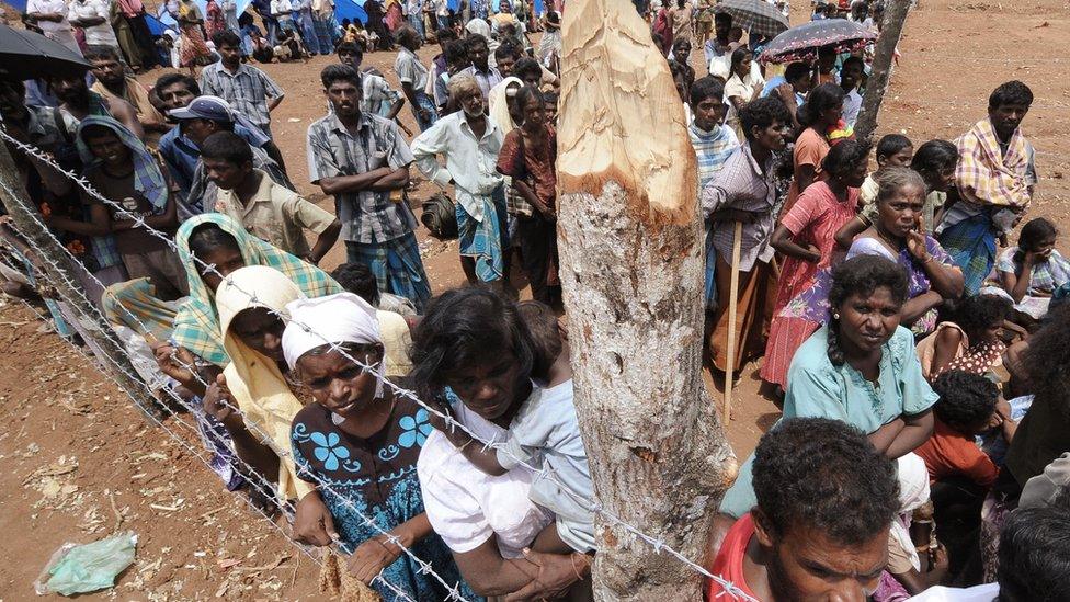 Internally displaced Sri Lankan people look on during a visit by United Nations Secretary-General Ban Ki-moon at Menik Farm refugee camp in Cheddikulam on May 23, 2009