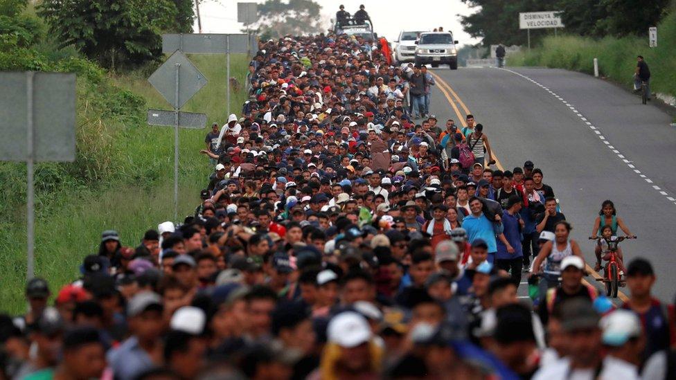 Migrants, part of a caravan travelling from Central America en route to the US, walk by the road that links Ciudad Hidalgo with Tapachula, 2 November 2018