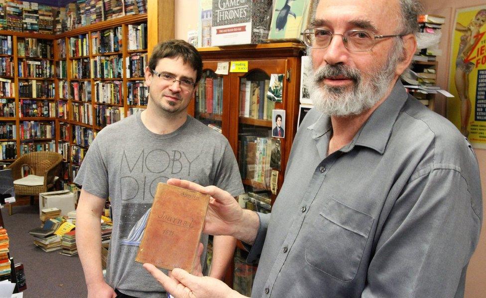 Co-owners of the Cracked and Spineless bookshop, Richard Sprent (left) and Mike Gray, with the journal, standing inside the shop