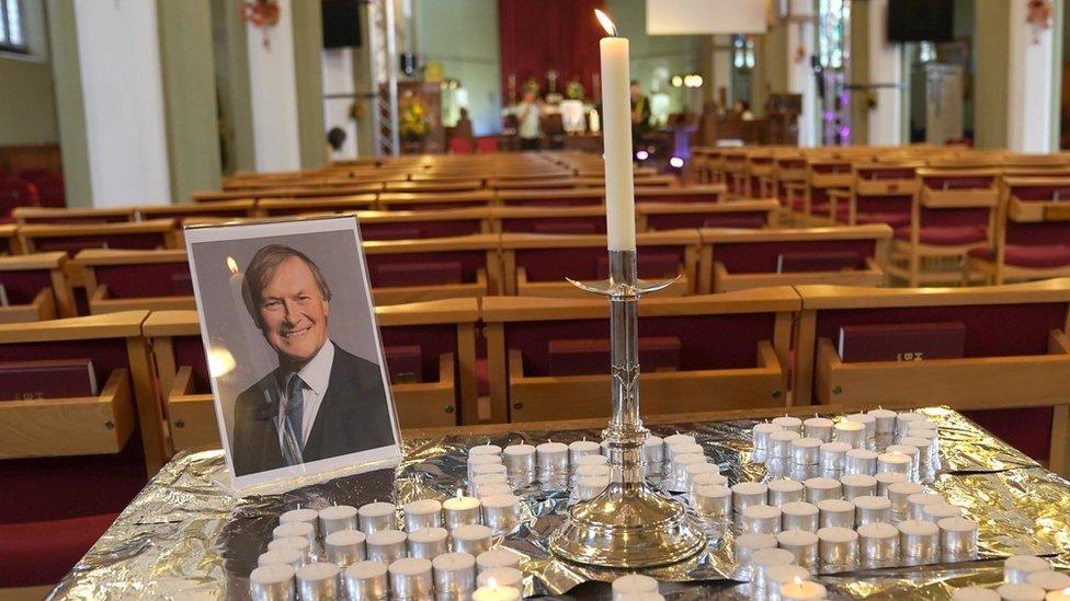 A photo of Sir David Amess at a vigil for him