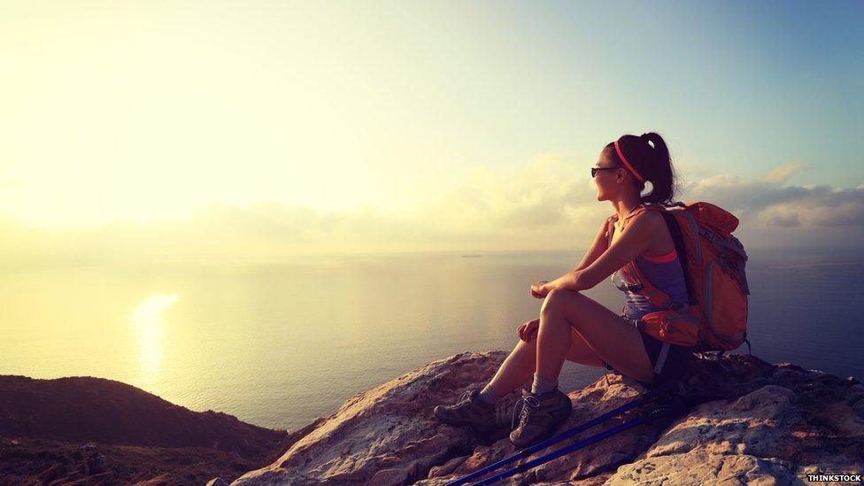 A backpacker sits near to a beach
