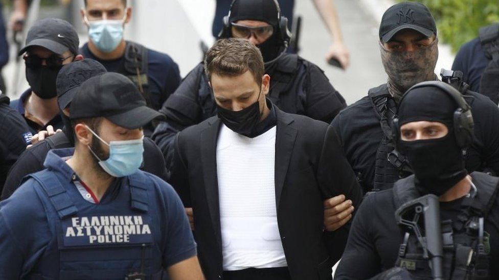 Babis Anagnostopoulos (centre) is escorted by armed police from Athens' court, Greece. Photo: 18 June 2021