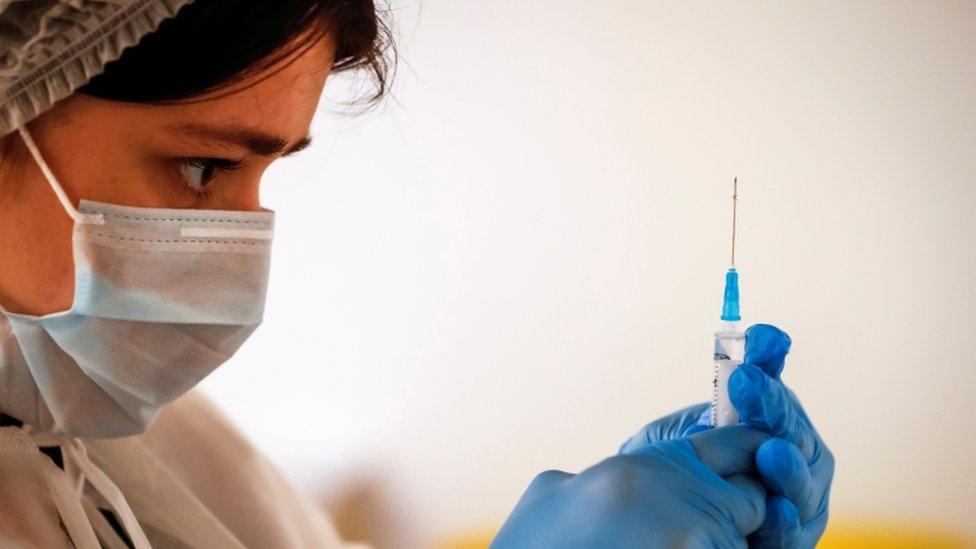 A healthcare worker prepares a dose of Sputnik V at a food mall in Moscow