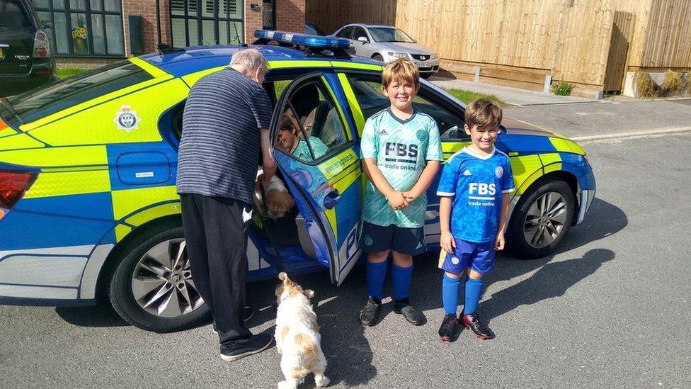 Alfie and Jenson by the police car