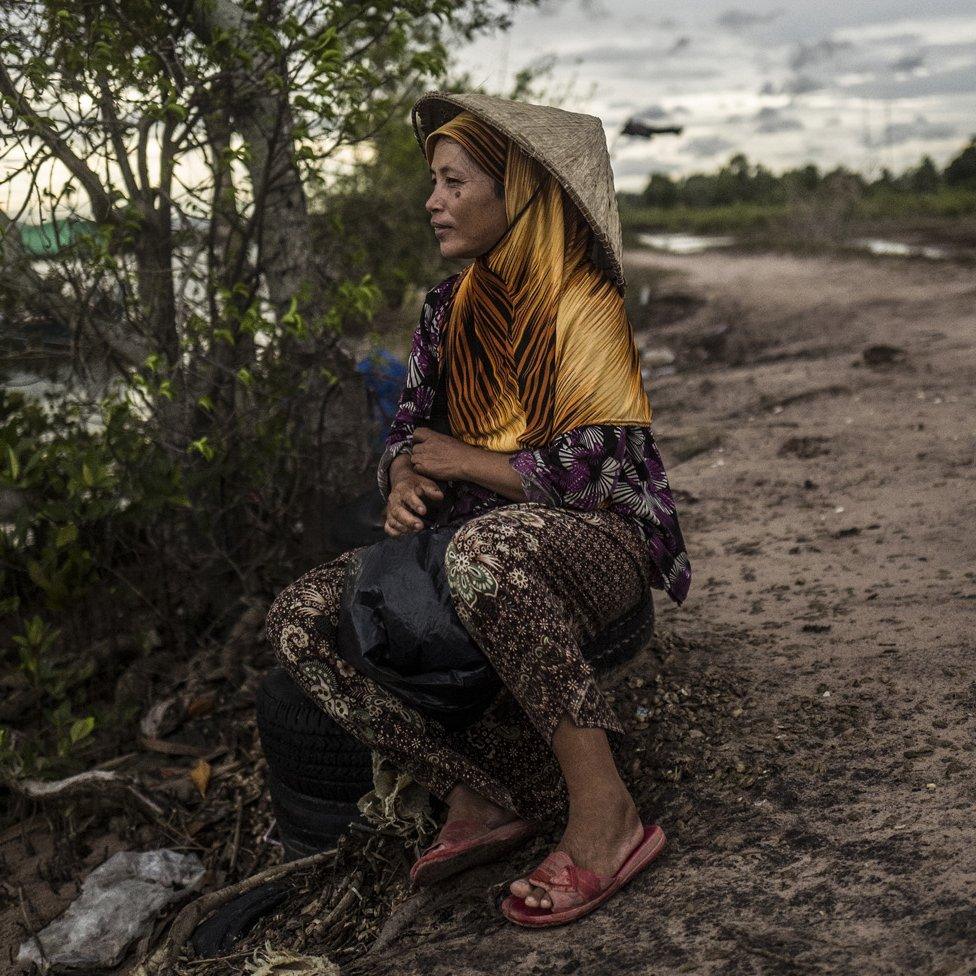 A woman waits for the fishermen to return