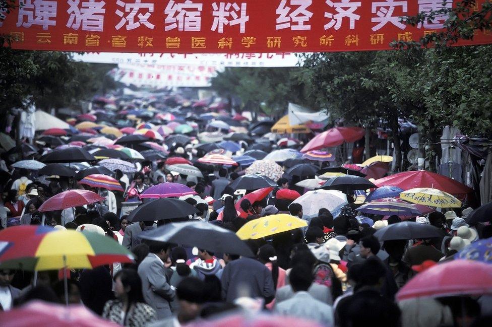 People attending a festival in China hold umbrellas