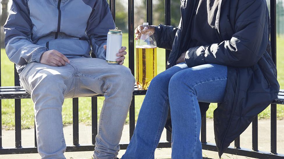 Teenagers drinking alcohol in a park