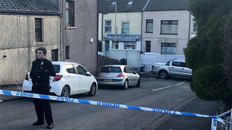 A police cordon and police officer in front of the Blue Sky Chinese restaurant