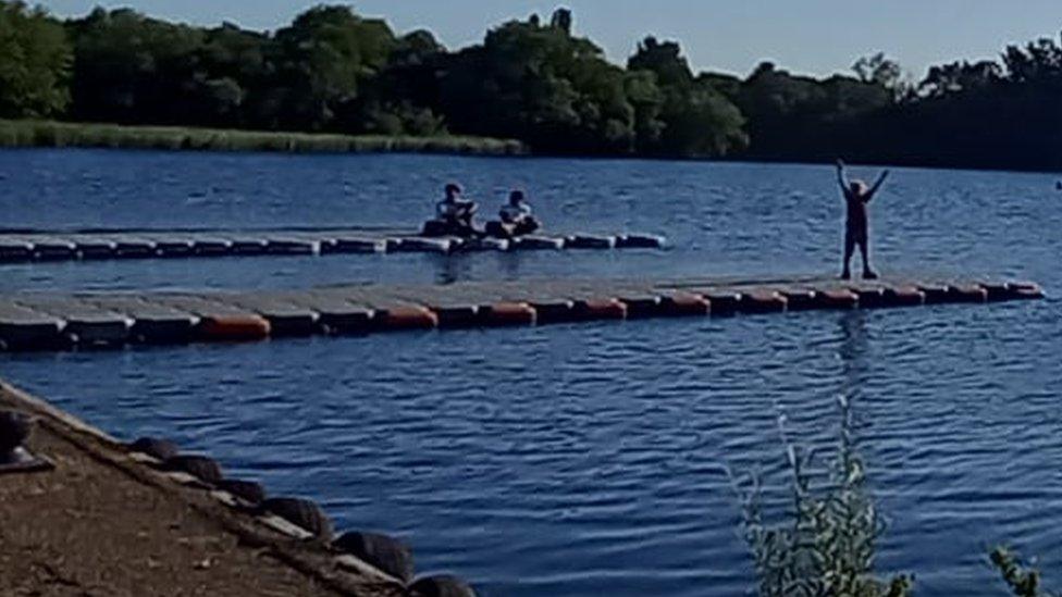 Picture showing three boys on two jetties at