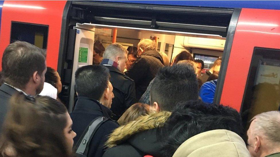 Passengers queue to get on to a South Western Railway train