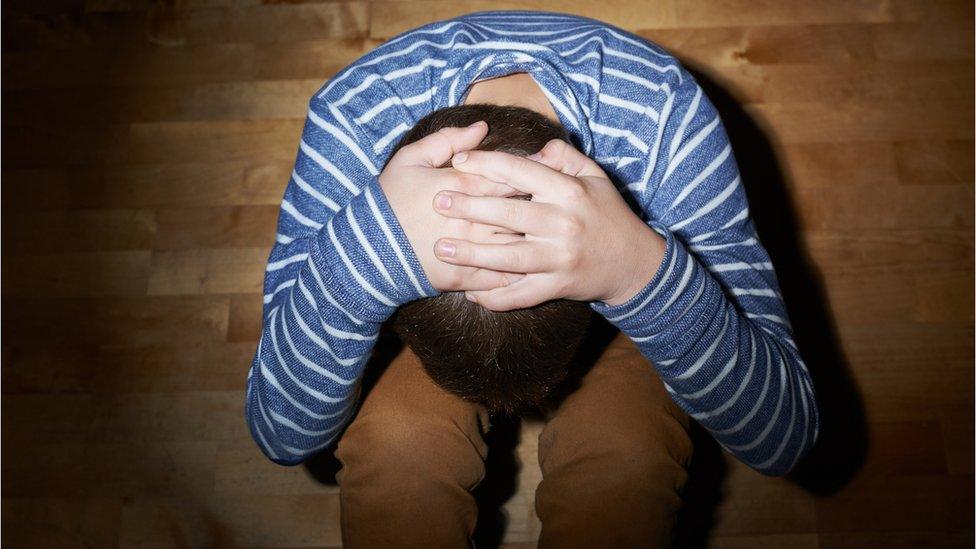 A child holds his head in his hands