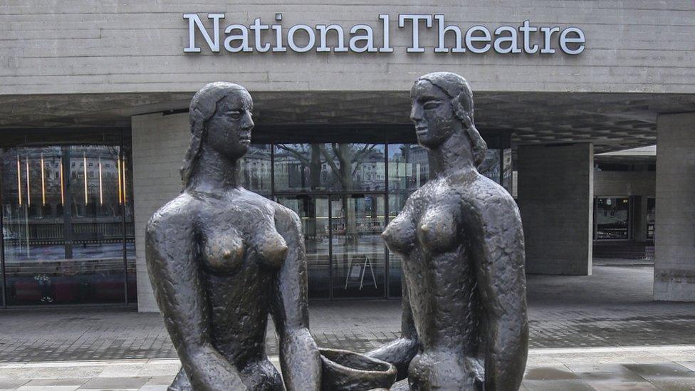 A statue of two women outside the front of the National Theatre