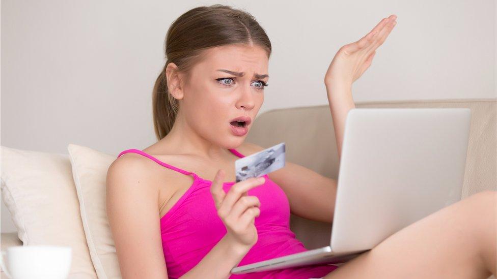 Young woman with lap top and card