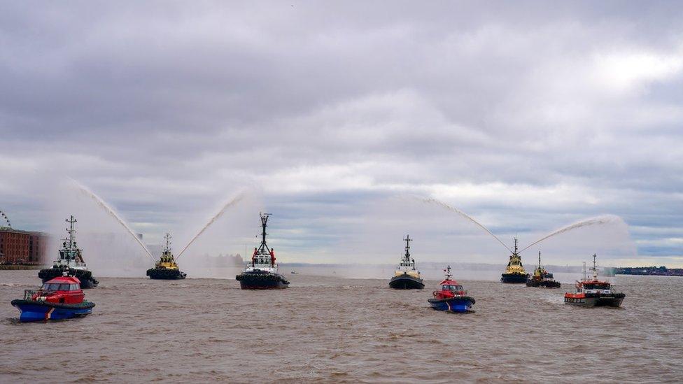 River tugs perform Fleur De Lis, (spraying of water from their fire cannons) as vessels gather on the River Mersey in Liverpool