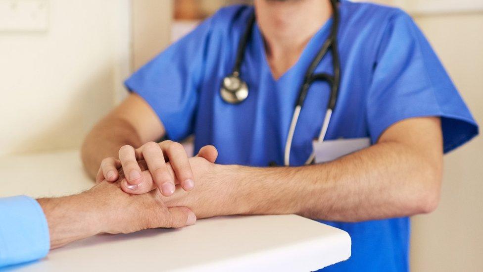 Nurse holding patients hand