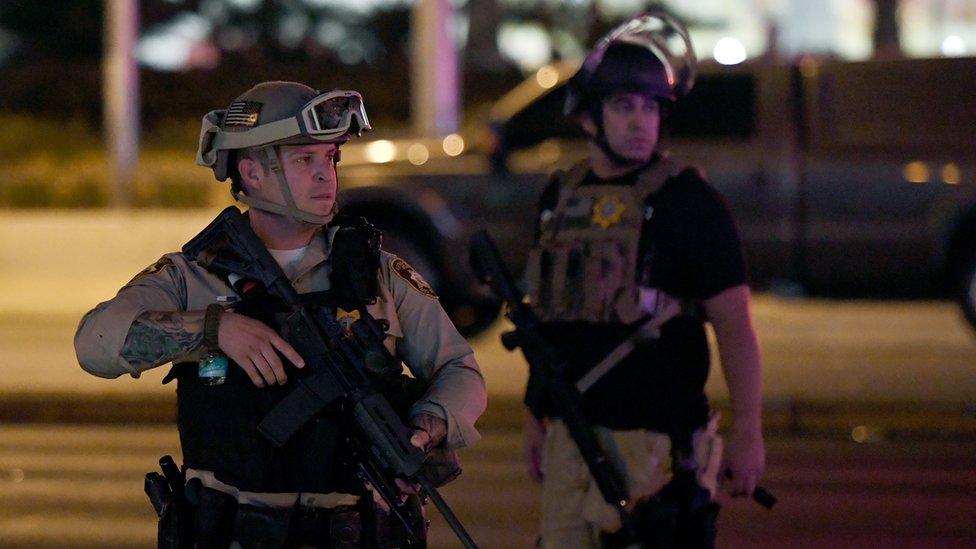 police with faces visible looking tense on street