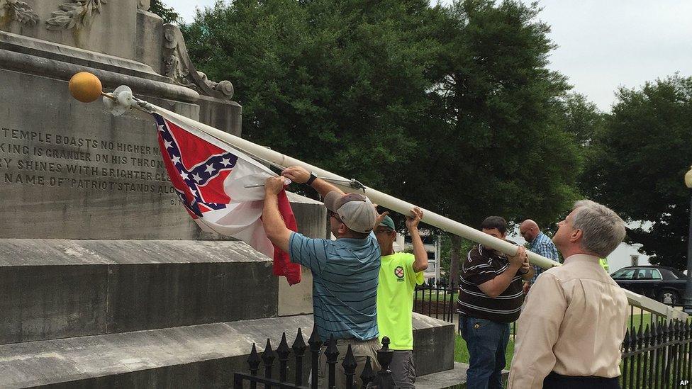 State workers take down a Confederate national flag on the grounds of the state Capitol, Wednesday, June 24, 2015, in Montgomery, Ala.