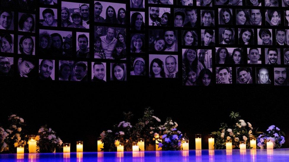 Candles are lit in front of the photos of the victims of the downing of Ukraine International Airlines flight PS752, in Toronto, Canada (8 January 2023)