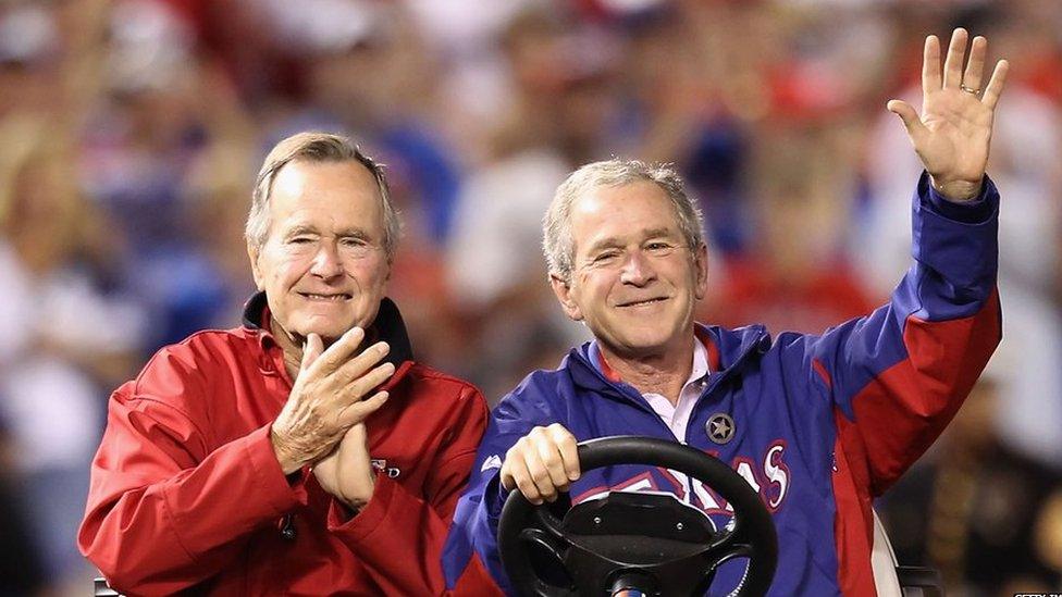 George W Bush and his father George HW Bush wave to the crowd before the Texas Rangers host the San Francisco Giants in Game Four of the 2010 MLB World Series at Rangers Ballpark in Arlington on October 31, 2010 in Arlington, Texas.