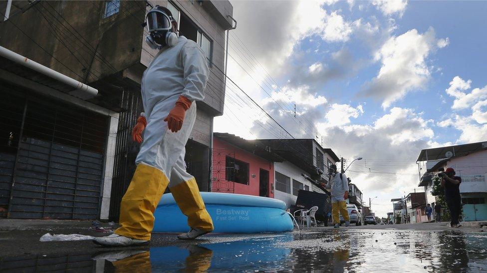 Health workers walk while fumigating in an attempt to eradicate the mosquito which transmits the Zika virus in Recife, Pernambuco state, Brazil in 2016