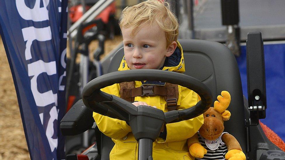 A young boy on ride-on lawnmower at the Balmoral Show