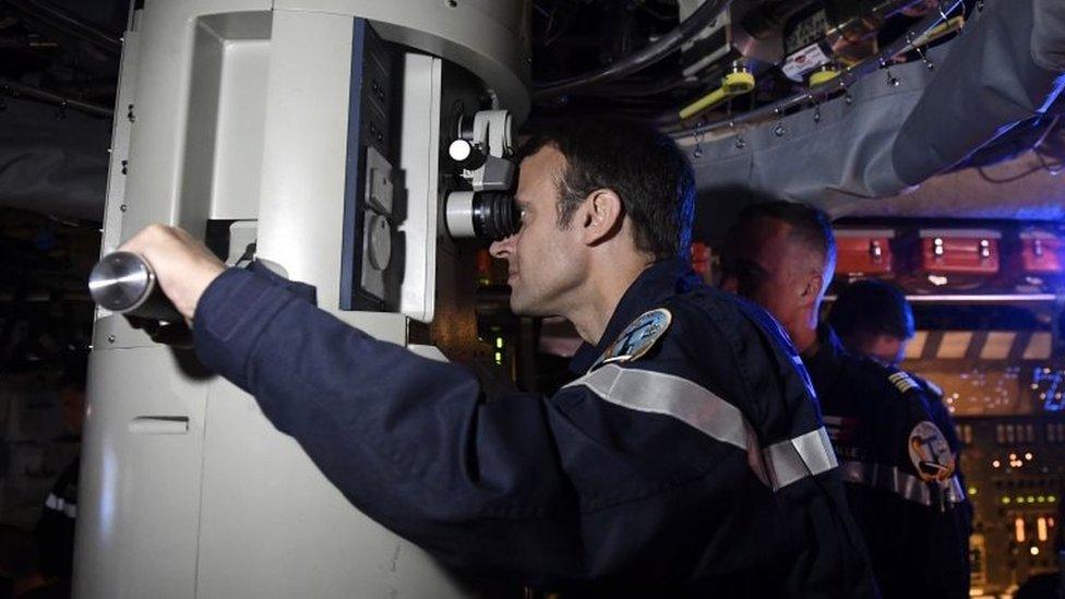 President Macron looks through the submarine's periscope