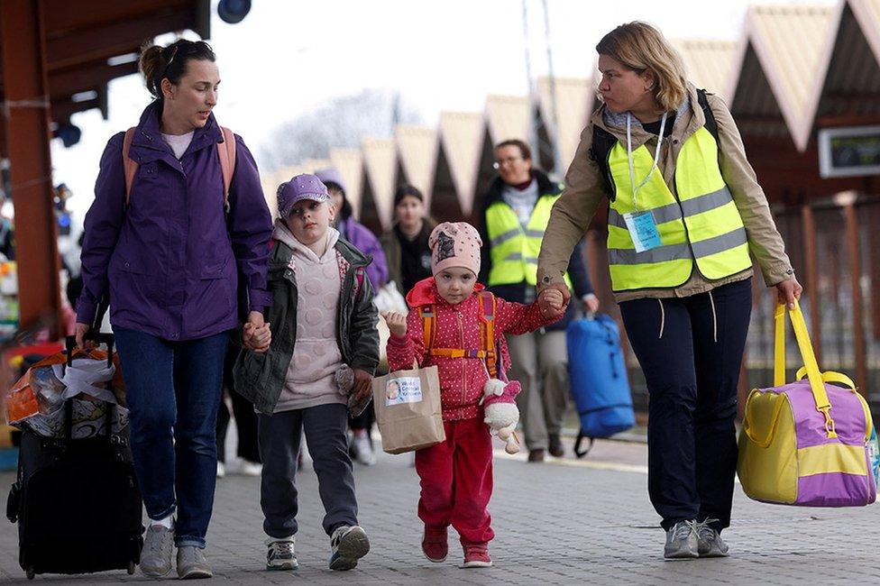 Ukrainian refugees walk on the platform after arriving on a train from Odesa