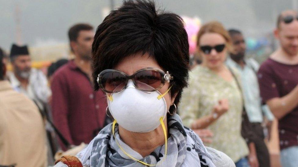 A foreigner wearing an anti-pollution mask walks a street in New Delhi, India, 5 November 2016.