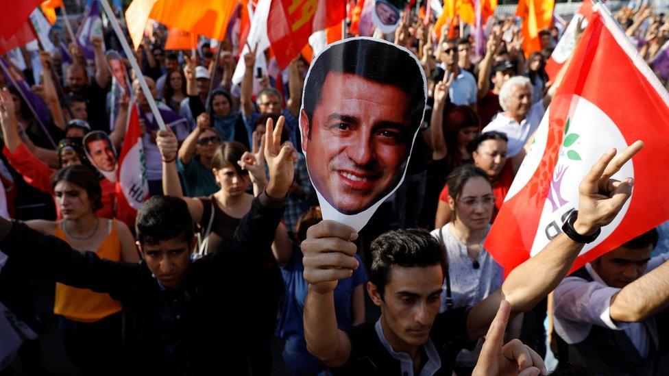 Supporters of Turkey's main pro-Kurdish Peoples' Democratic Party (HDP) hold masks of their jailed former leader and presidential candidate Selahattin Demirtas