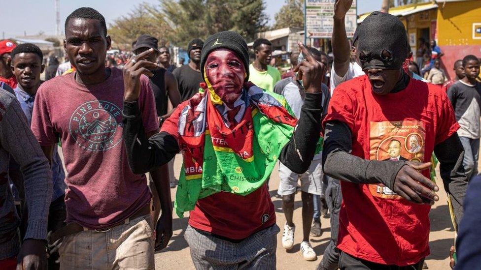 A supporter of the Zambian opposition party United Party for National Development of the presidential candidate Hakainde Hichilema gestures during a motorcade parade in Matero, Lusaka, on August 10, 2021