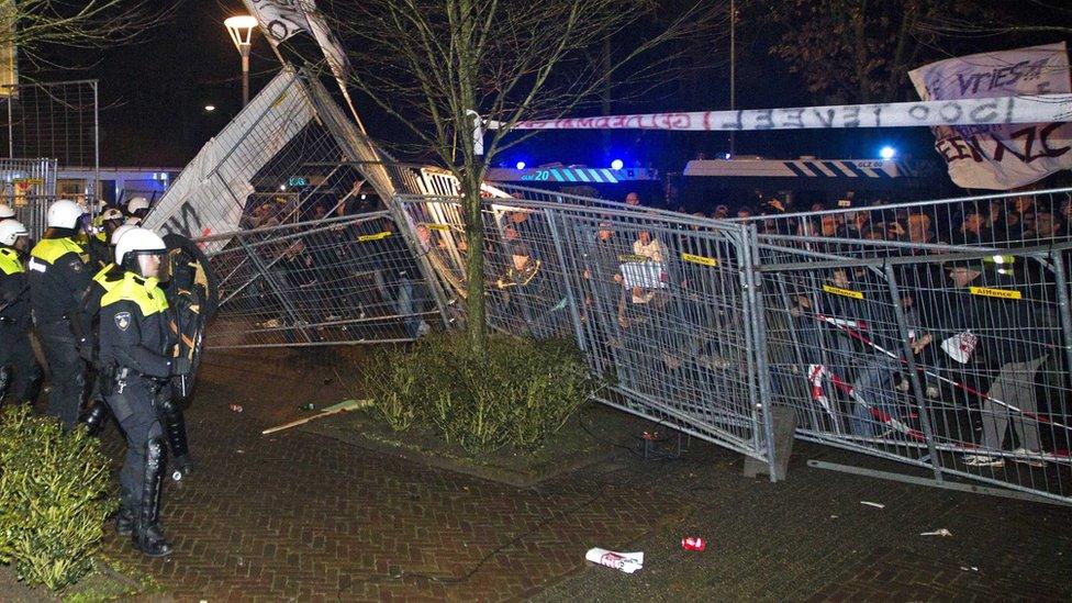 Riot police look on at a protest in the Dutch down of Geldermalsen