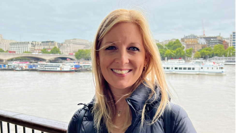 A woman queueing by the River Thames