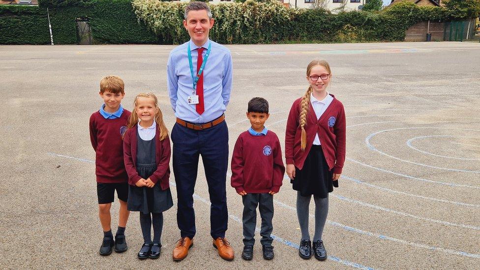 Head teacher and pupils in a school