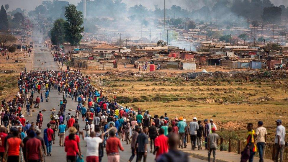 A mob armed with spears, batons and axes run through Johannesburg's Katlehong Township during a new wave of anti-foreigner violence on September 5, 2019