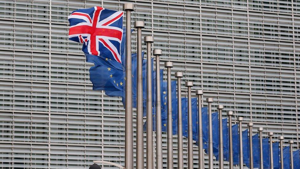 A Union Jack flag flies next to European Union flags