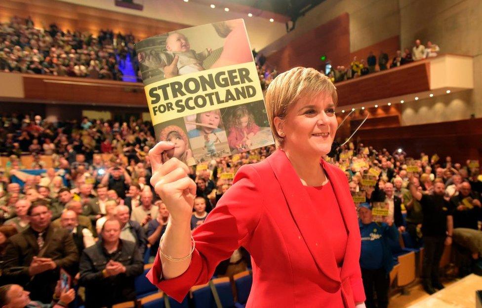 SNP leader Nicola Sturgeon holding the party's manifesto