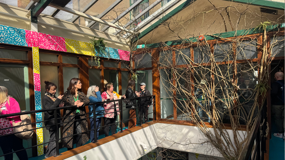 Crowd on balcony inside Show Some Love Green House