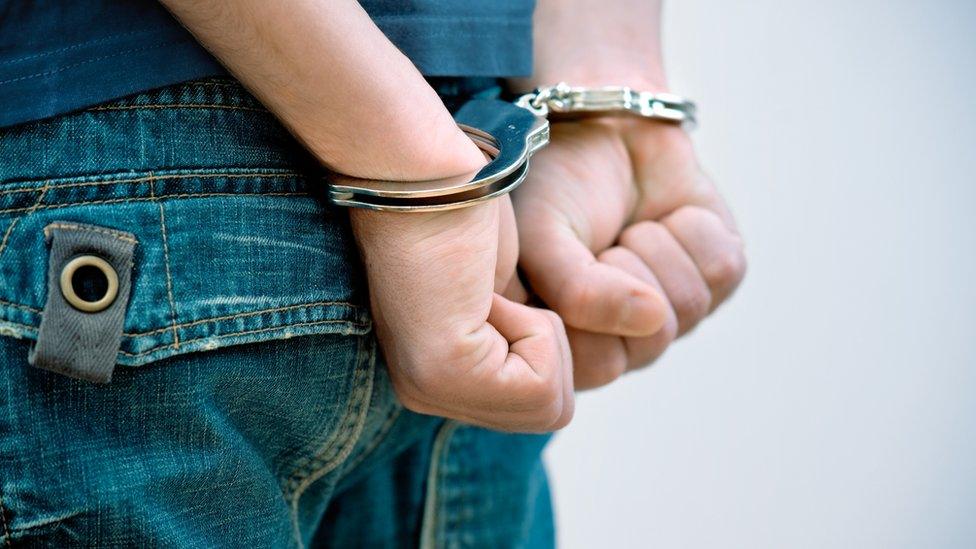 Young man in handcuffs stock picture