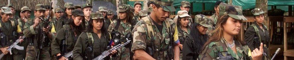 Marxist FARC rebels march through a guerrilla camp deep in the jungles of southern Colombia, 22 June 2001.