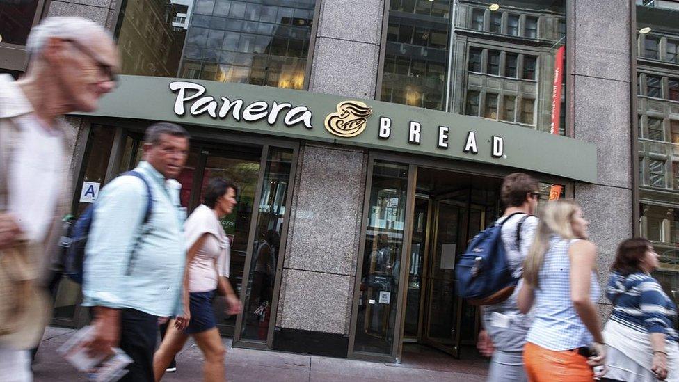 People walk past Panera Bread branch