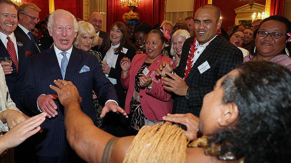 King Charles III reacts as former Samoan rugby player Freddie Tuilagi dances during a reception to celebrate the Commonwealth Diaspora of the United Kingdom, ahead of the Commonwealth Heads of Government Meeting in Samoa, at St. James's Palace, in London on October 2, 2024.