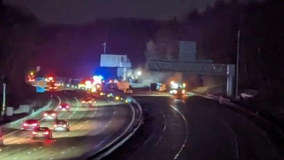 Night-time image of the road at the time of the crash, cars can be seen and smoke is in the distance