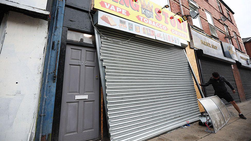 Broken shutter on a tobbaco and vape shop which was ransacked