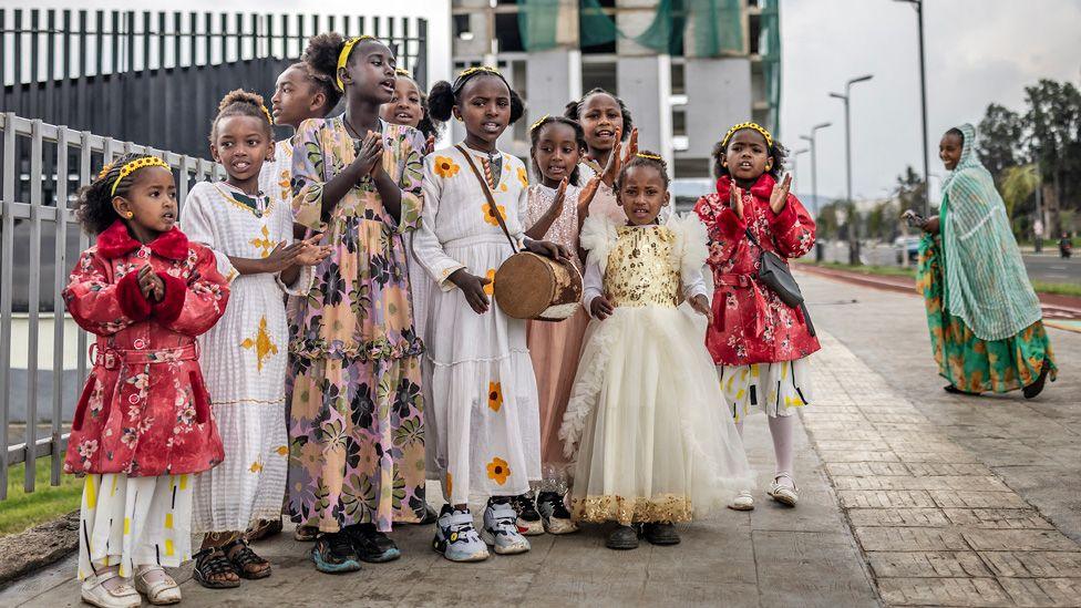 A group of 10 girls wearing yellow flowers, a symbol of the New Year, play drums and sing seasonal songs for passers-by in Addis Ababa, Ethiopia - Thursday 11 September 2025.